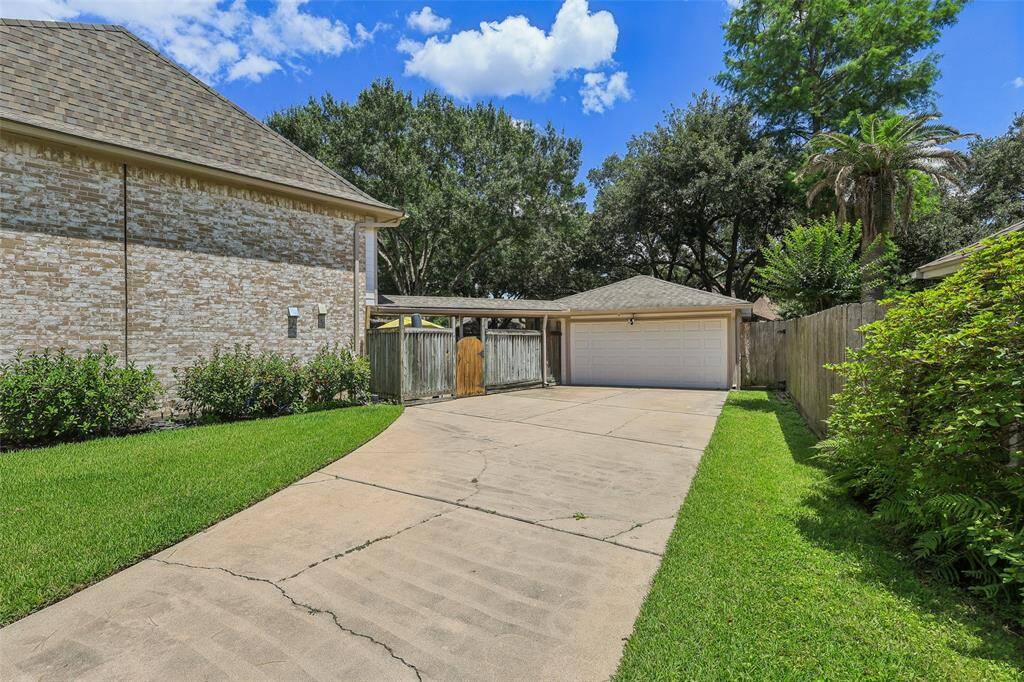 Spacious lot with a long driveway leading to a detached garage, in a quiet, established neighborhood