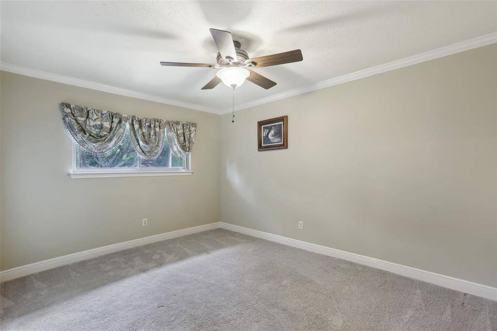 2nd bedroom offering ceiling fan and crown molding