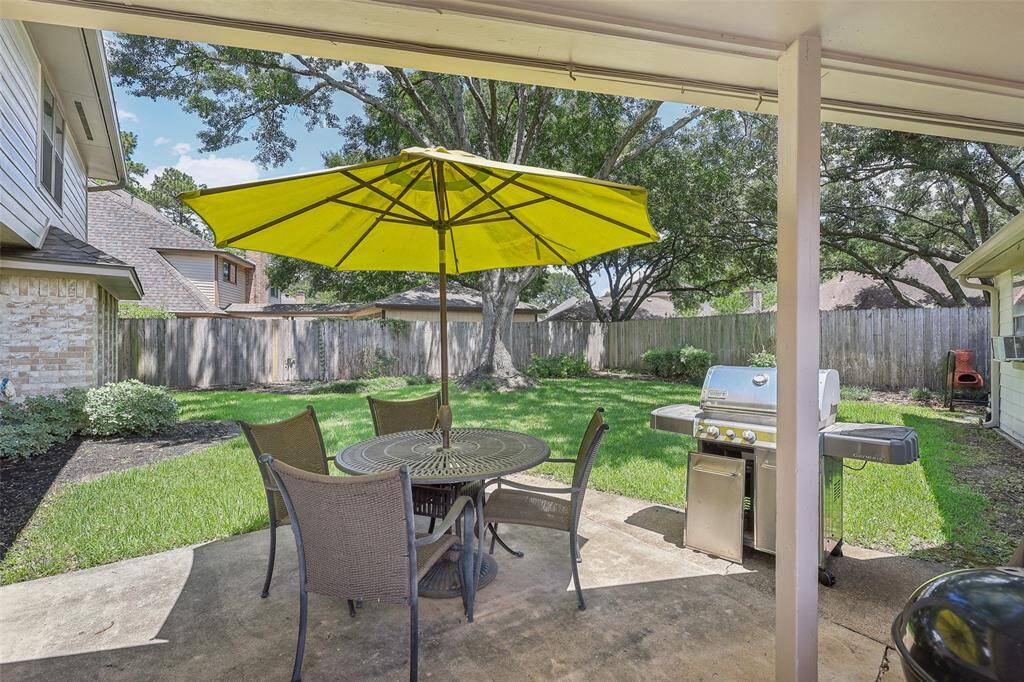 Patio space overlooking a large backyard, perfect for outdoor gatherings, relaxing, or enjoying the spacious yard