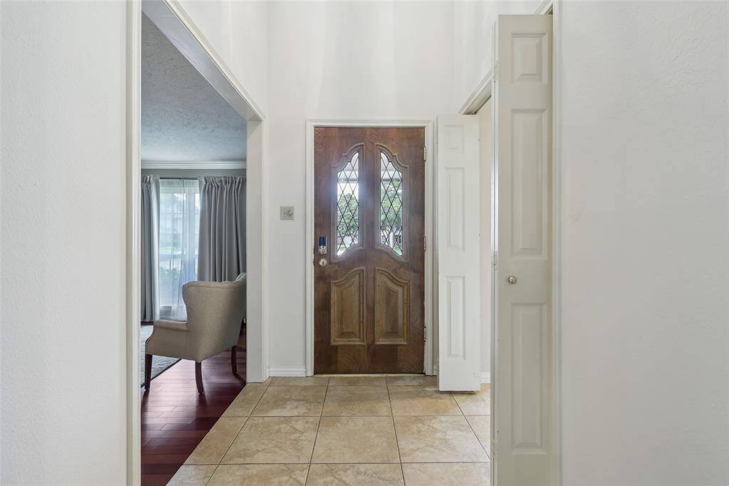Inviting entry features tile flooring and a clear view leading to a private study or formal living room, setting the tone for flexible living space