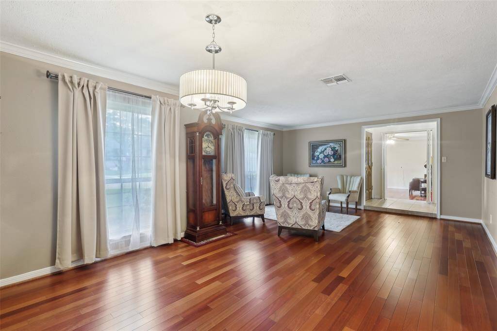 Spacious formal living and dining area with hardwood floors that make the room feel open, warm, and inviting—ideal for entertaining
