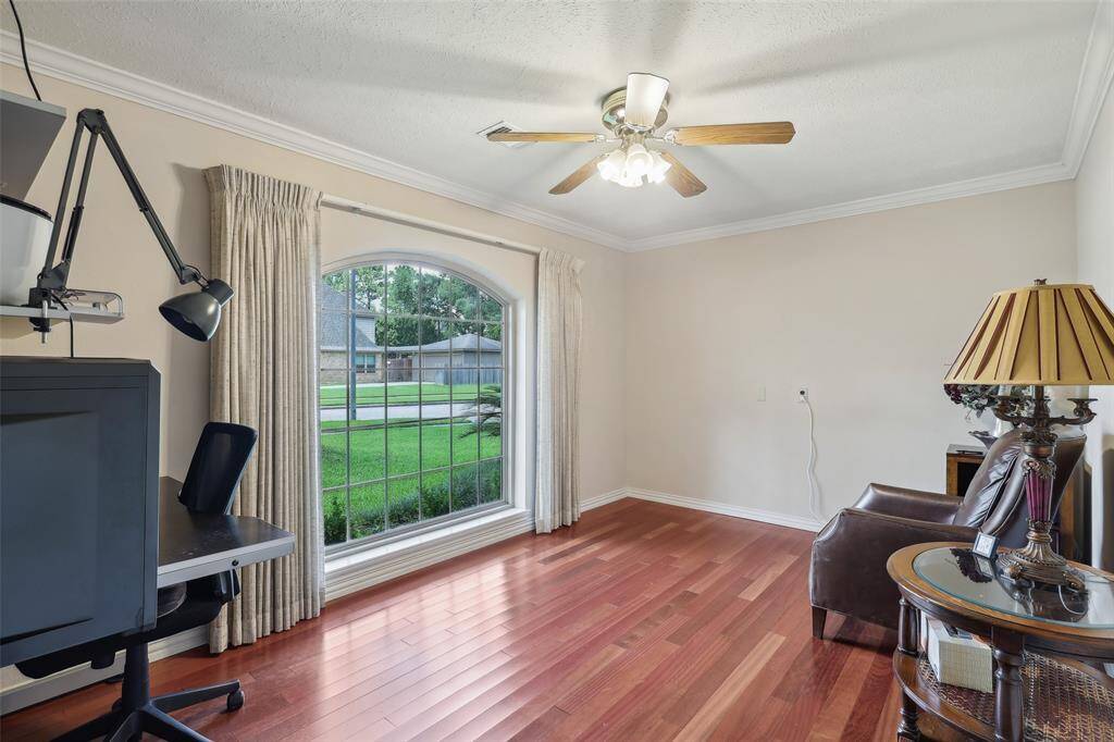 Private study with rich hardwood floors and a large window that fills the room with natural light—perfect for working from home or quiet reading