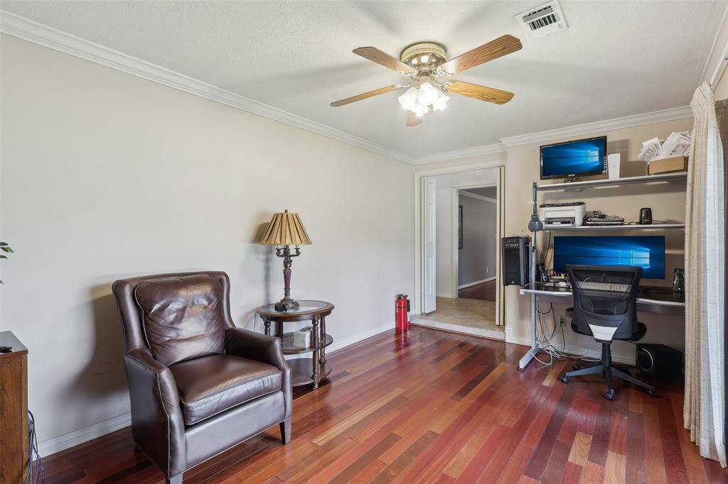 Alternate view of the private study, showcasing the elegant hardwood floors, double doors for privacy, and the spacious feel enhanced by natural light from the large window