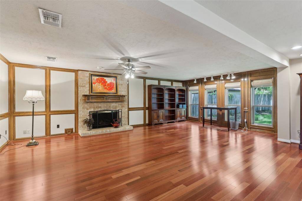 Large family room featuring beautiful hardwood floors and original traditional wood paneling, adding character and warmth to the space