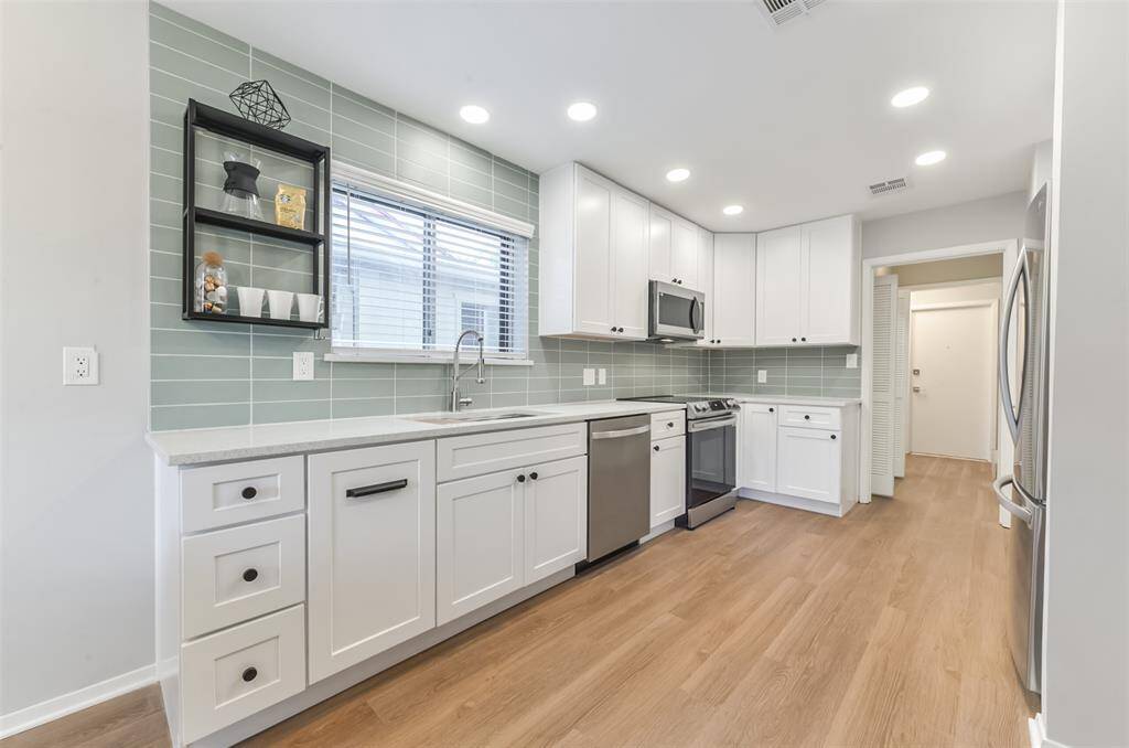 View of full updated kitchen towards laundry room and front of the home. You will love how bright and clean this home looks!