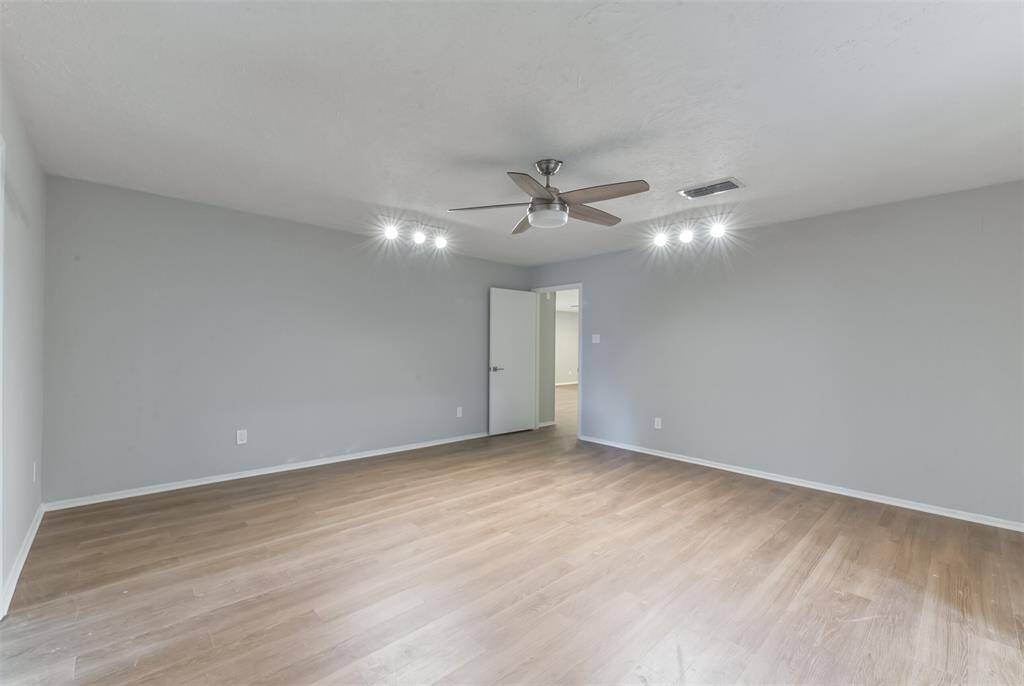 Very spacious primary bedroom with modern ceiling fan and no carpet!