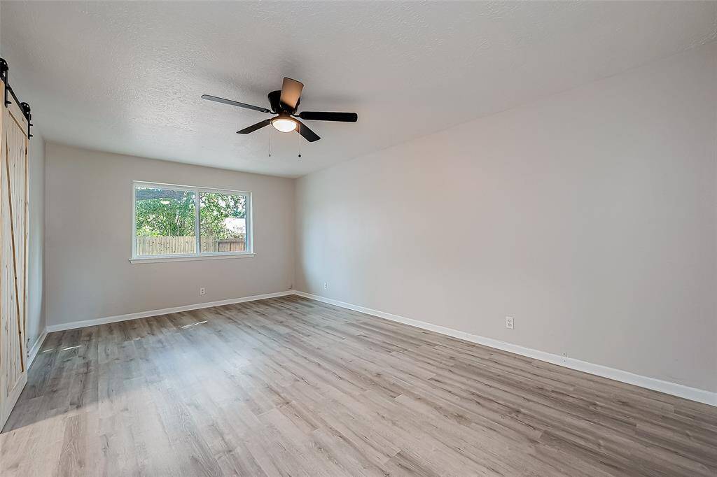 Long and flexible primary bedroom with a back yard view.