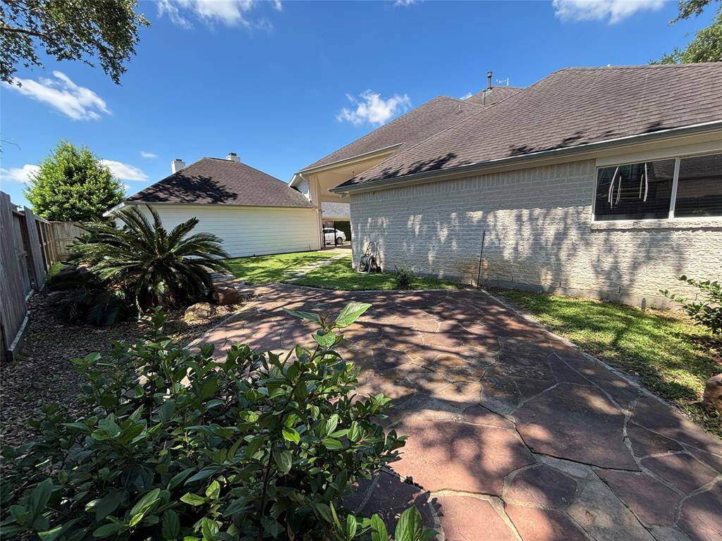 This kitchen boasts high ceilings, ample natural light, and a spacious layout. It features granite countertops, a central island with a cooktop, and modern appliances. The hardwood floors add warmth, complementing the elegant cabinetry. Ideal for cooking and entertaining.
