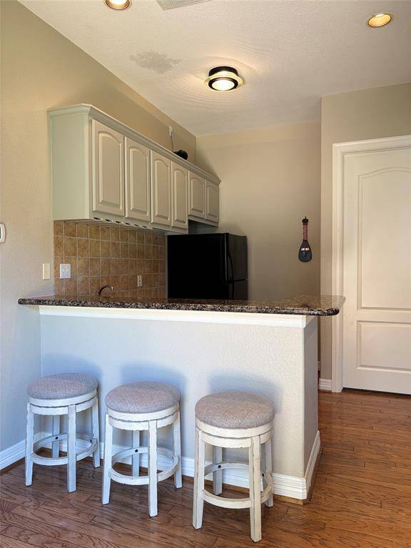 This bathroom boasts a spacious walk-in shower with a glass partition, elegant tiled surfaces, a sleek white vanity with a large mirror, and stylish modern lighting.