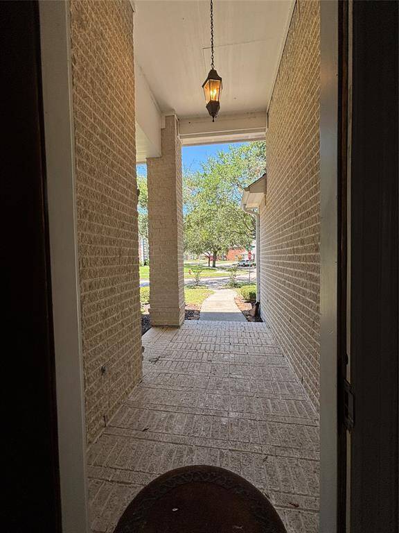 Step into a stunning entryway featuring soaring ceilings, elegant tile flooring with a decorative inlay, and refined architectural details including arched wall niches and crown molding. A classic chandelier adds a warm and welcoming touch, while the open layout draws your eye toward the heart of the home