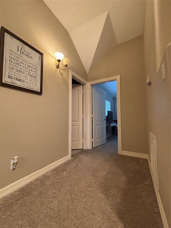 The first upstairs bedroom showcases a cozy yet stylish design with sloped ceilings, a ceiling fan with light fixtures