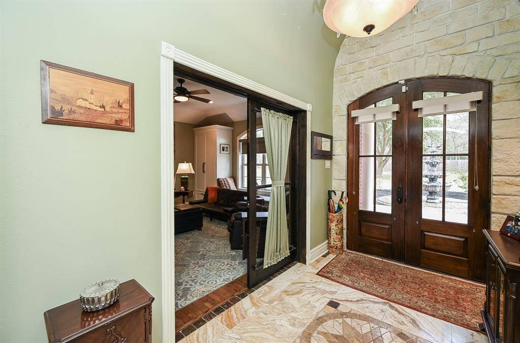 Office or media room off to the left, doubled glass doors. You can also install a murphy bed wall for multi use function room. Stone wall as you can see and custom treatments on doors for natural light.