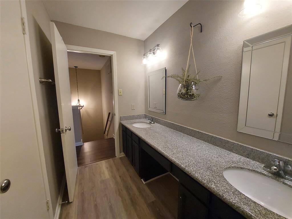 Guest bath has 2 sinks inset with granite and all wood cabinets and vanity.