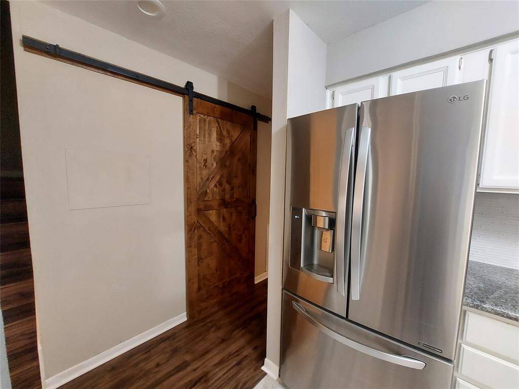 Custom made Barn Door opens up to the utility and half bath! This view if from the kitchen which shows off the LG Side by Side included in your purchase.