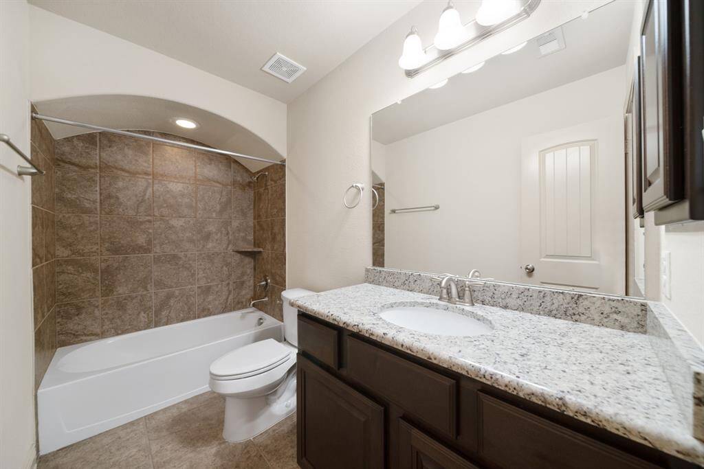 Full bathroom upstairs with granite counters and a shower/tub combo.