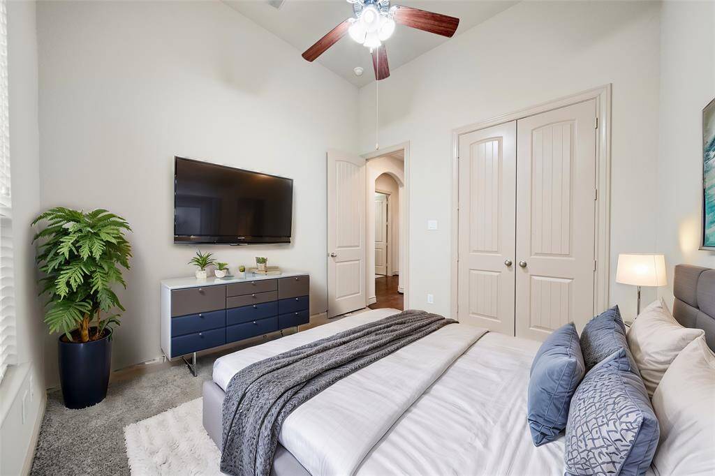 Secondary bedroom downstairs with high ceilings, carpet, a ceiling fan and 2" blinds!
