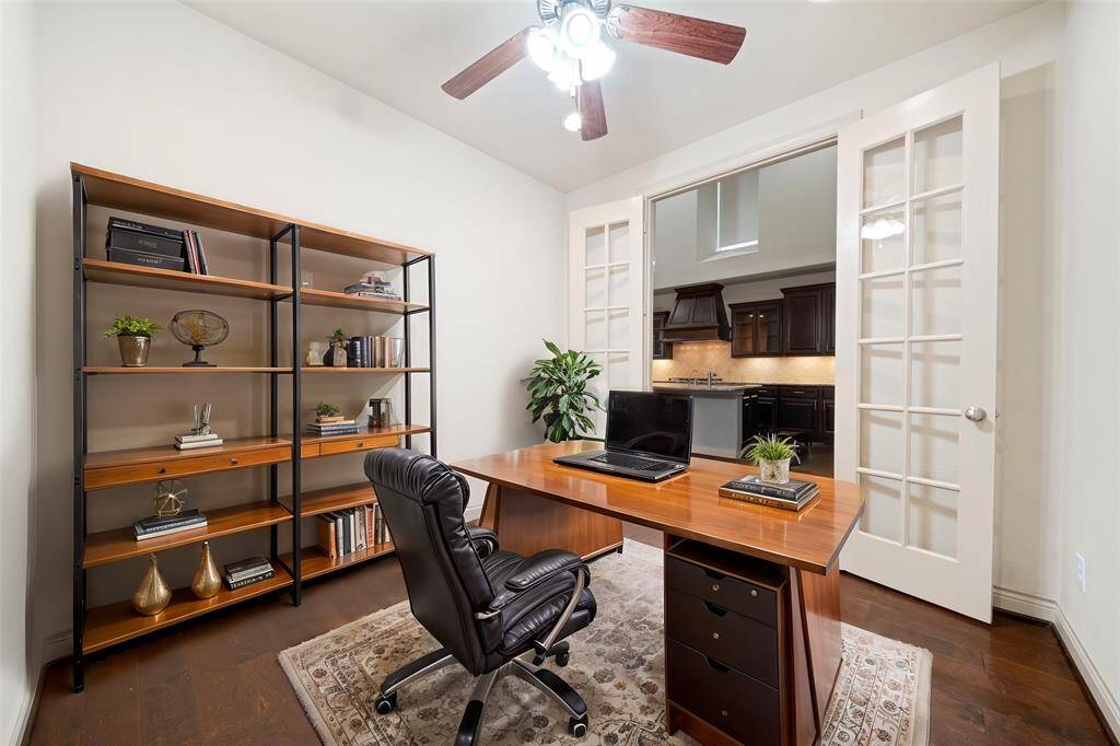 Study with French doors, wood flooring & a ceiling fan.