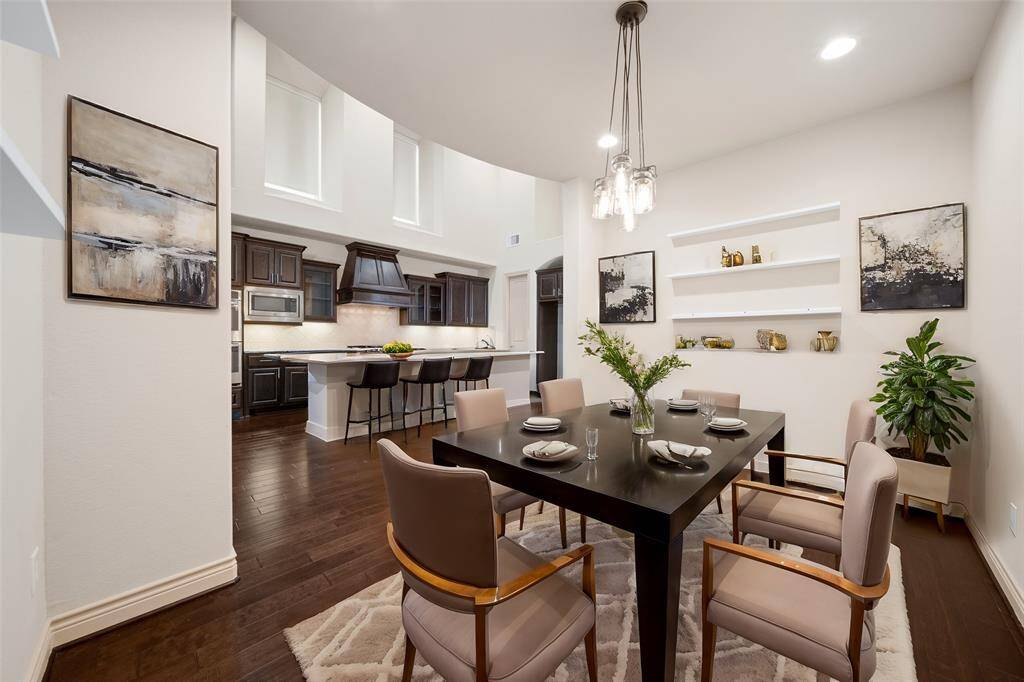Wood flooring continues to the dining room, illuminated by recessed lighting & a modern chandelier!