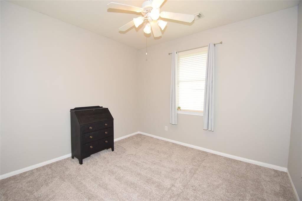 Bedroom offering a ceiling fan with light fixture, window blinds and nice closet space.