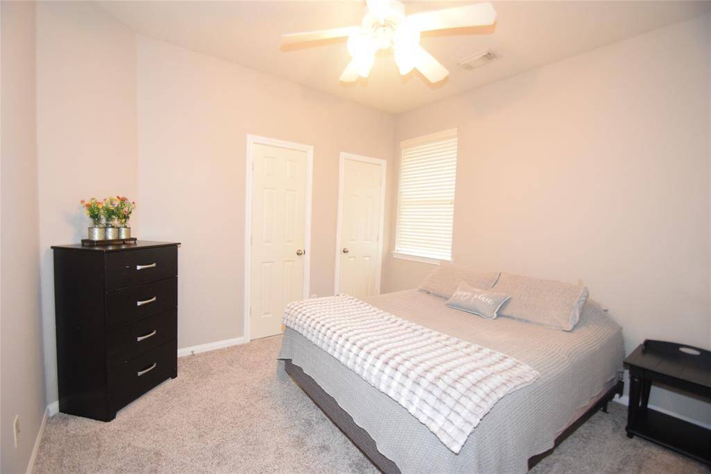 Bedroom offering a ceiling fan with light fixture, window blinds and nice closet space.