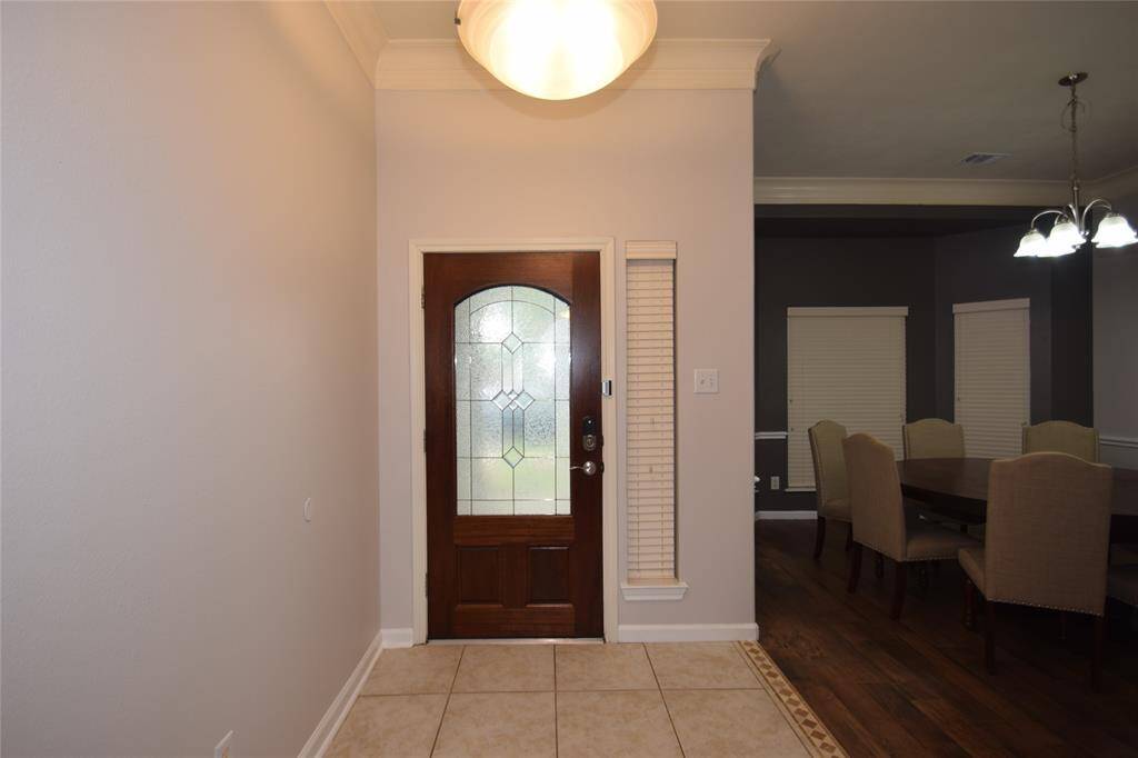 Elegant entry with a beveled glass front door, tile floors and opens to the dining room.