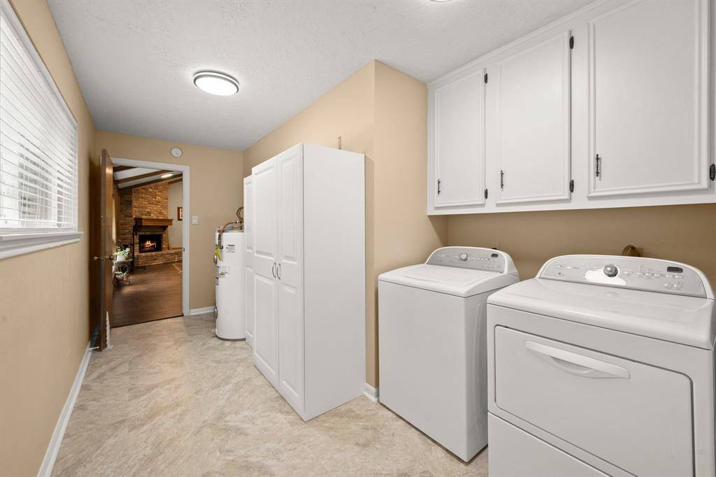 Large laundry room houses the water heater offering longer life by being protected from attic heat and potential moisture and rust.