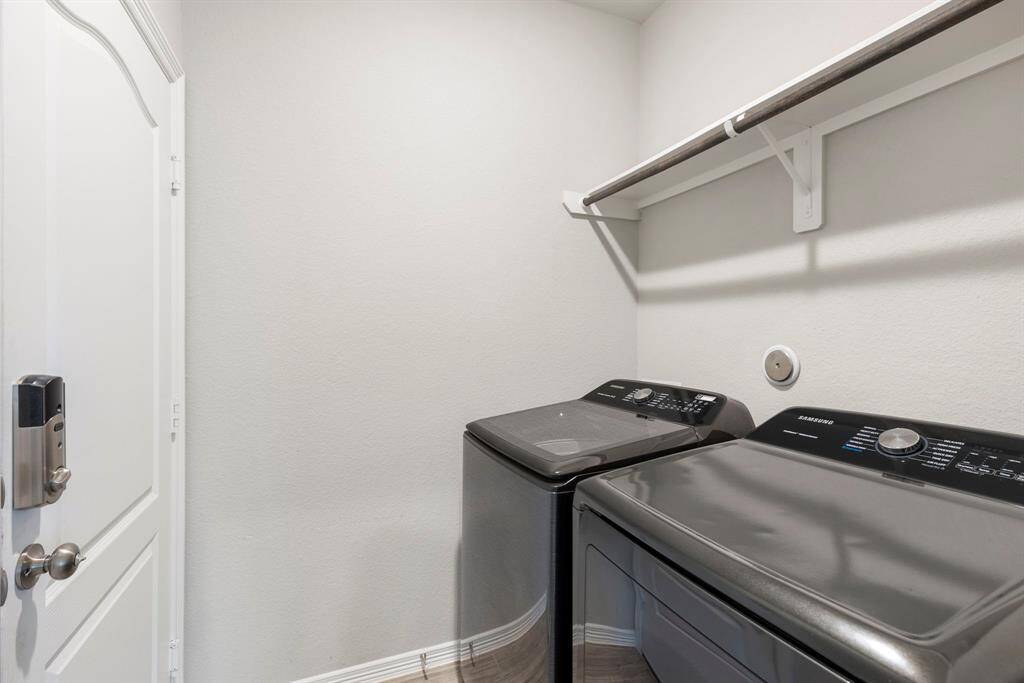 Utility room is nice size with tile flooring and custom shelving.