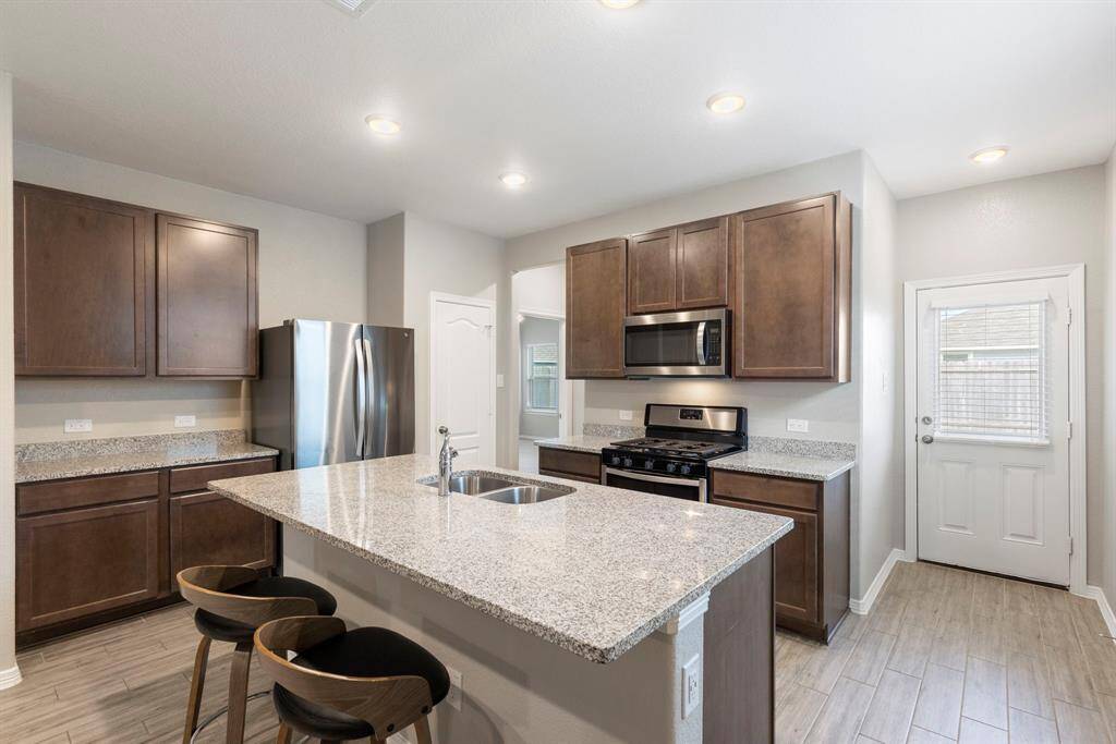 Island kitchen features granite counter tops, under counter lights and more