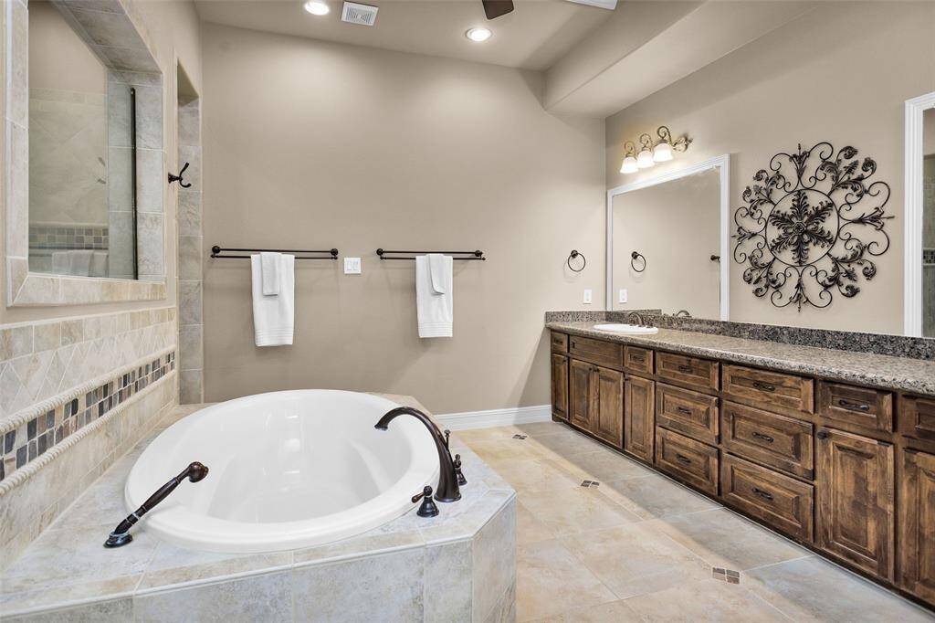 The luxurious bathroom features a spa-like shower, soaking tub, and double vanity.