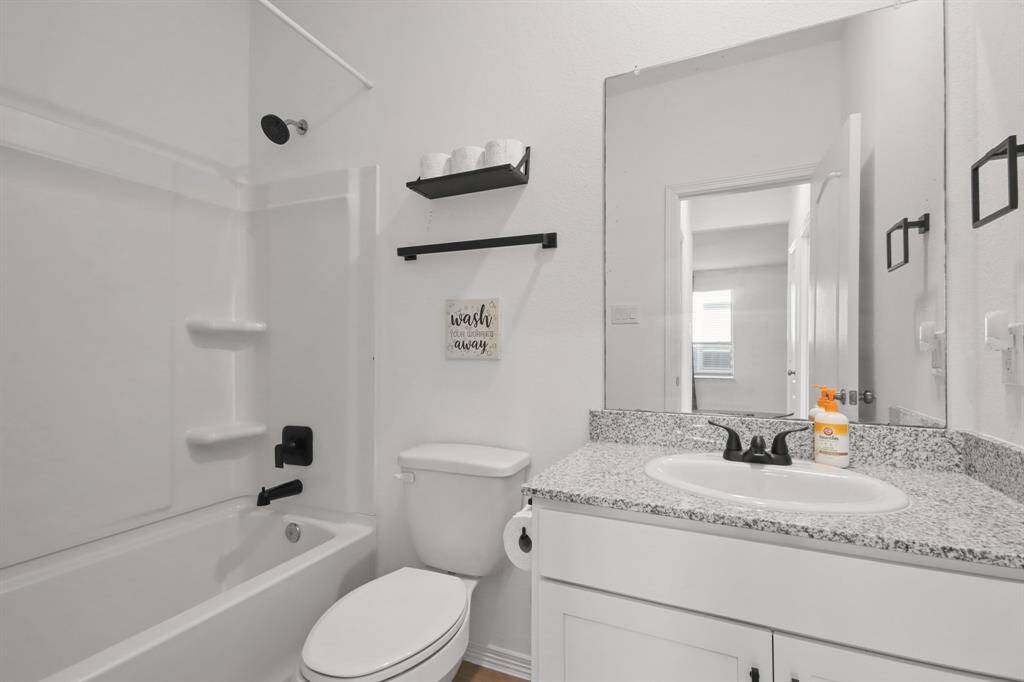 Secondary Bedroom with granite countertops, and a shower/tub combo.