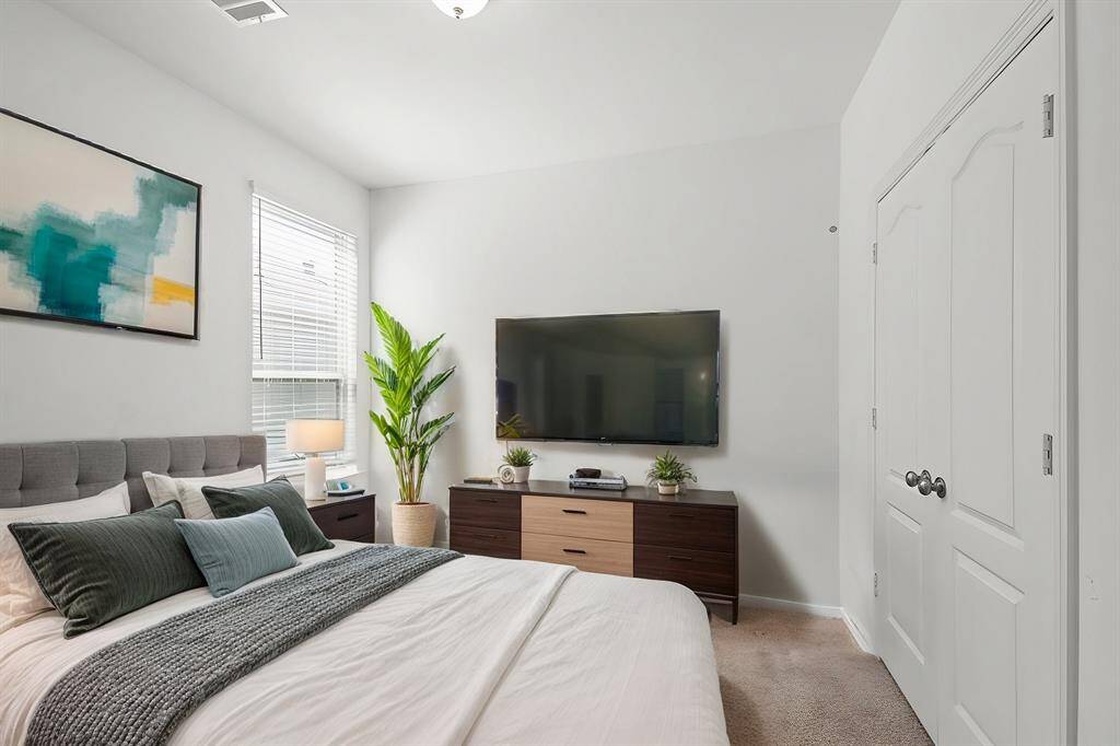 Virtually Staged: Secondary bedroom with carpet floors, windows with privacy blinds, and a built-in closet.