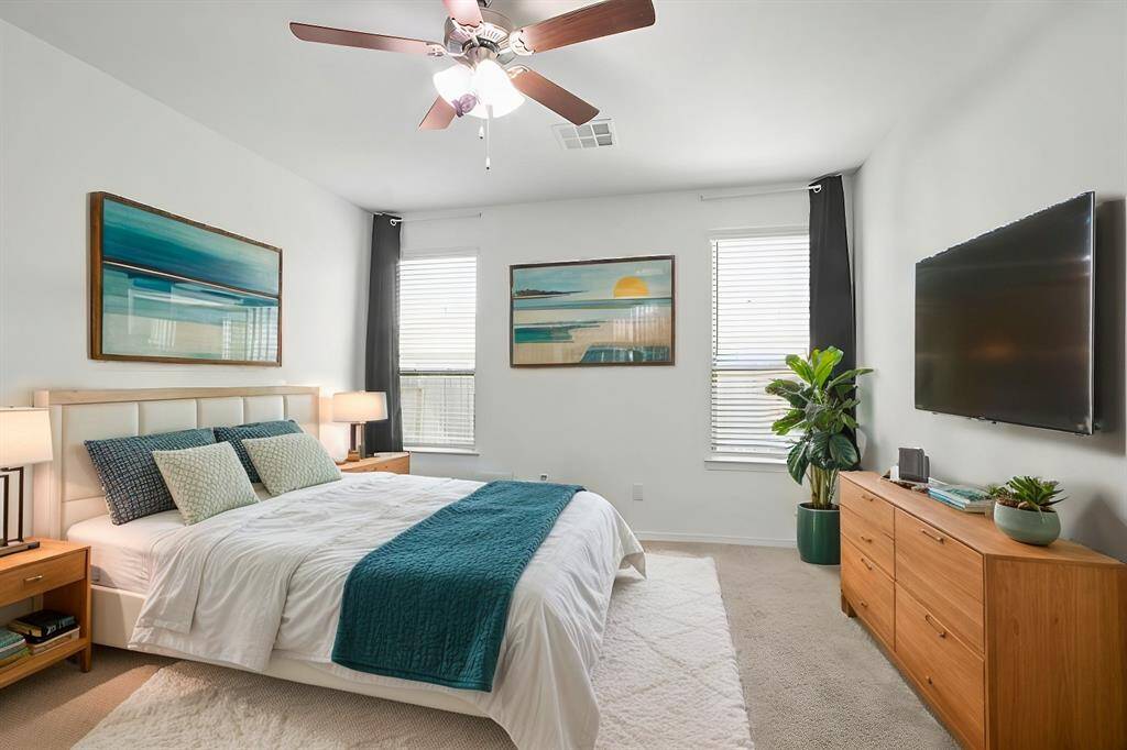Virtually Staged: This magnificent primary bedroom features carpet floors, large windows with privacy blinds, a ceiling fan, and an en-suite bathroom.
