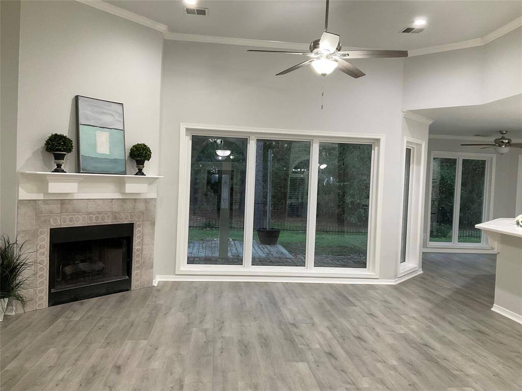 Bright living space with a wall of windows enjoying your private back yard.  The gas log. fireplace is open to the entire kitchen breakfast area, entry and dining area. Side door off the kitchen leads to the patio for outdoor cooking and entertaining.  Don't miss the two floor outlets, high ceilings or recessed lighting.