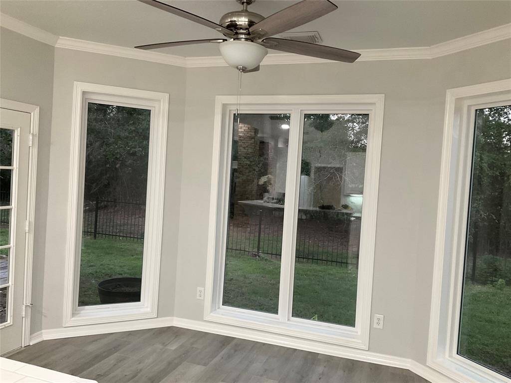 Breakfast area or a primary eating area with lovely lush green views.  New large double pane windows allow for an unrestricted view of nature.  Exterior door on the left leads to the covered back yard for outdoor cooking or dining creating a bright and inviting space.