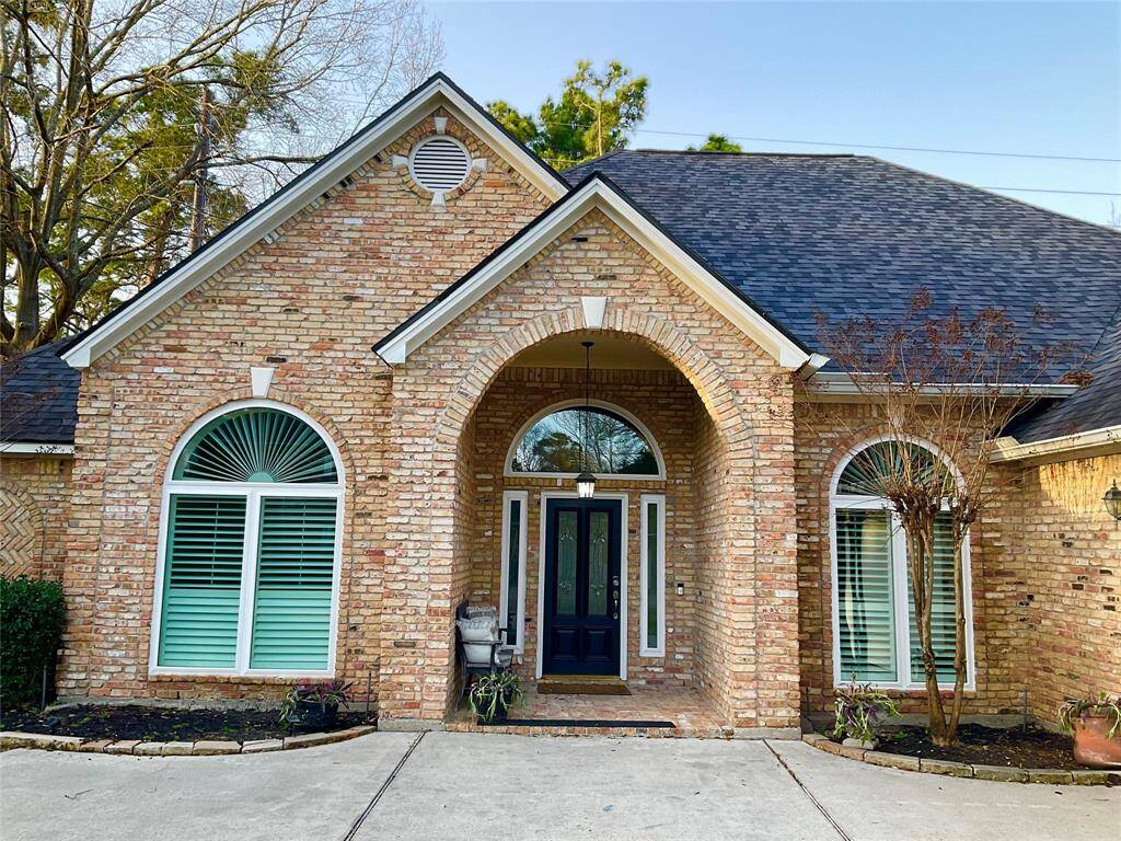 This home features a charming brick facade with an inviting covered arched entryway. Large, windows with shutters provide ample light, and the neatly landscaped front adds curb appeal. Ideal for buyers seeking a classic and welcoming exterior.