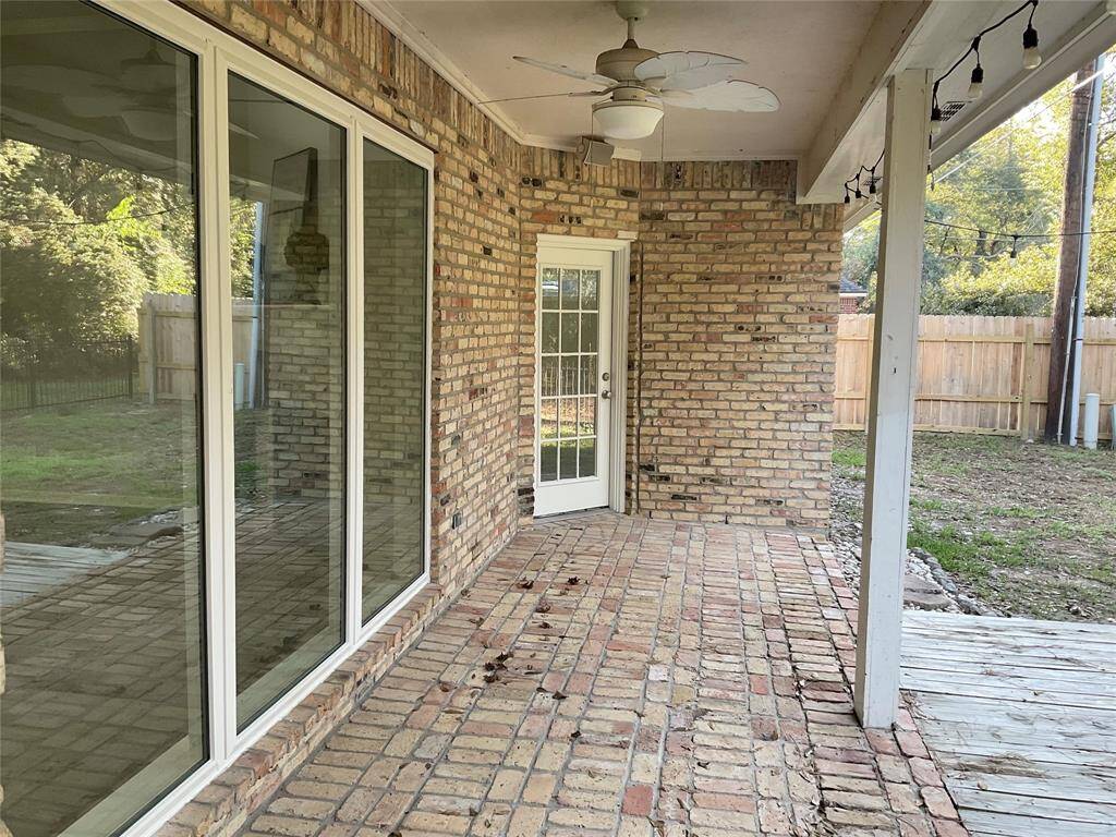 A charming, custom, brick home with a spacious covered back patio, ceiling fan and patio lights.  A space has been created for a fire pit if you want to sit outside and roast marshmallows.  There are 2 doors that lead to the interior.  One goes to the primary bedroom the other to the kitchen breakfast area.