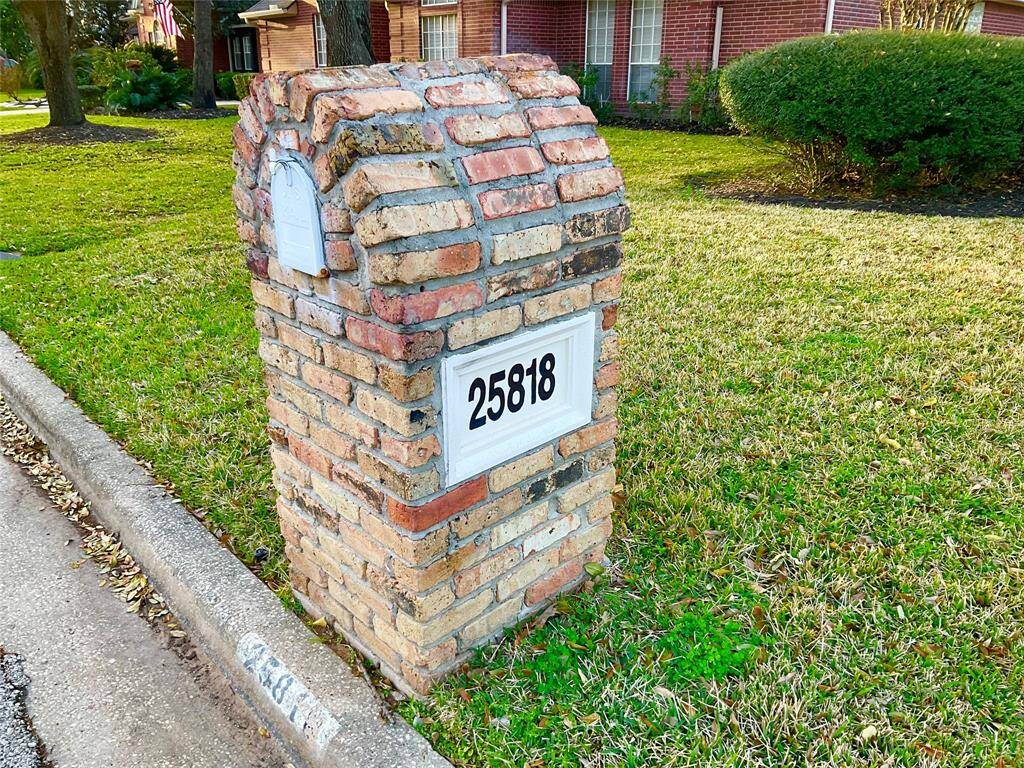 Charming brick mailbox with house number, set in a well-maintained lawn, enhances curb appeal in a suburban neighborhood.  No more cluster mailboxes!