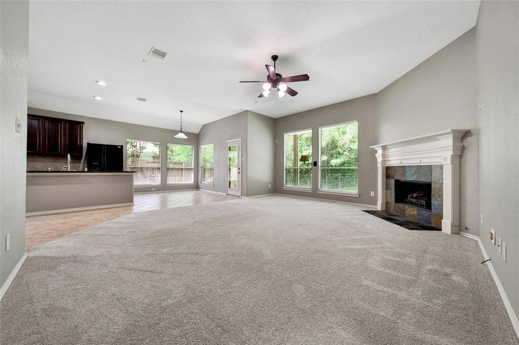 Windows overlook the large backyard and treed greenbelt behind the home.