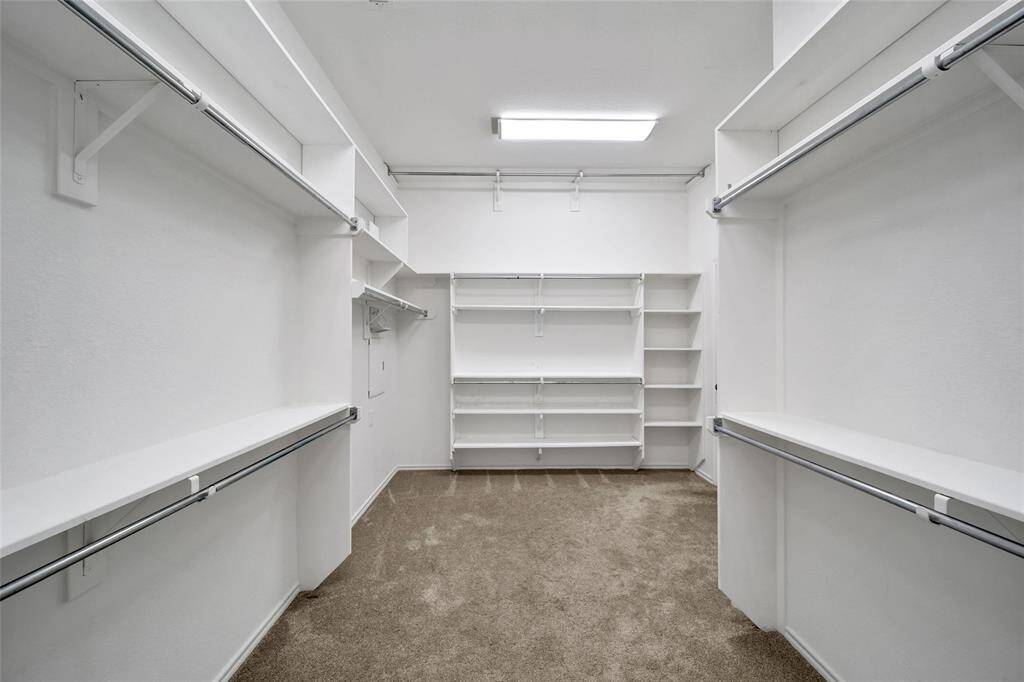 Massive walk-in closet for the primary bedroom that connects directly to the laundry room.