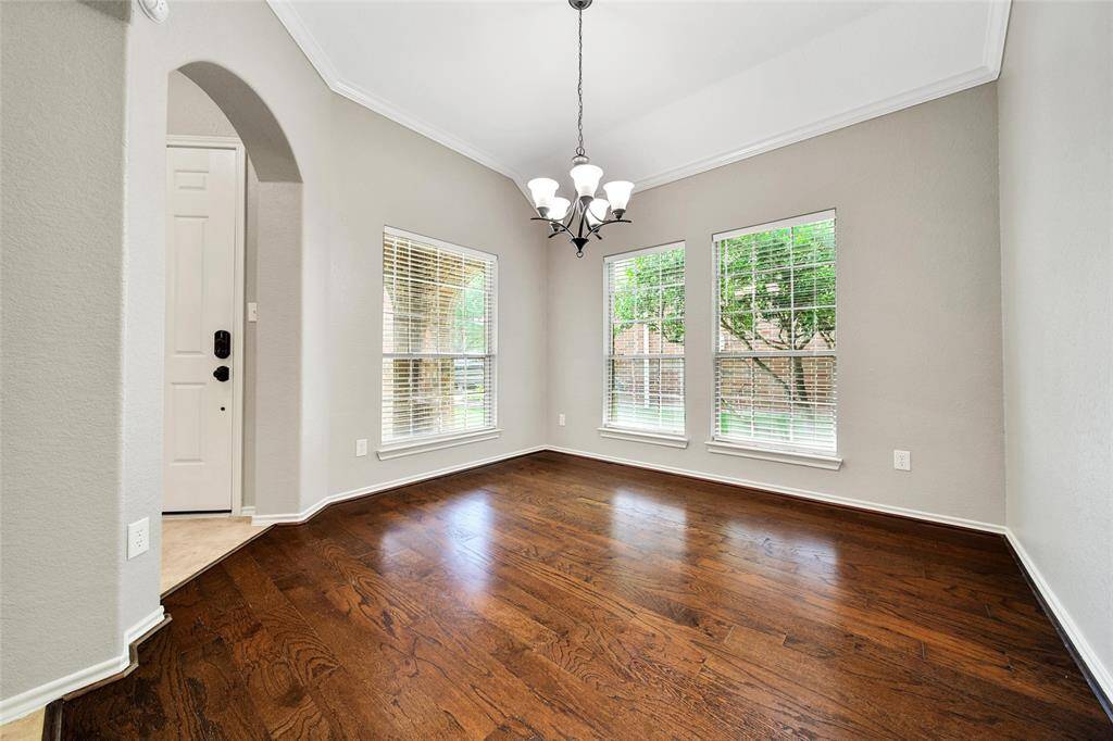 The formal dining room boasts large windows, gleaming wood floors, and crown molding making this a beautiful entertaining space.