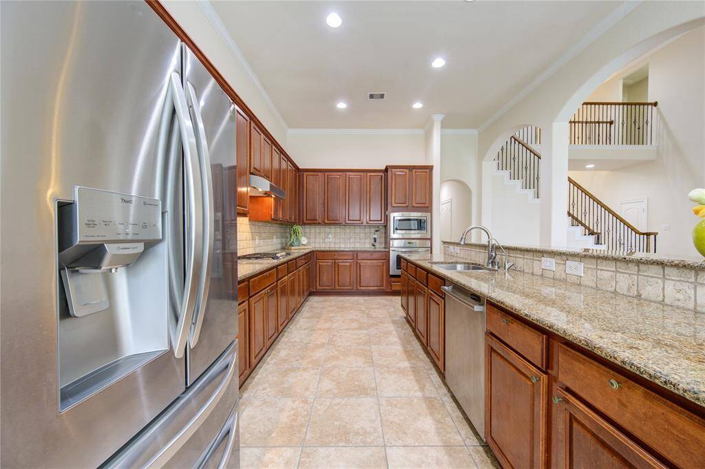The kitchen is ready for action: new SS fridge, plenty of countertops, recessed lighting and a long island with breakfast bar seating.
