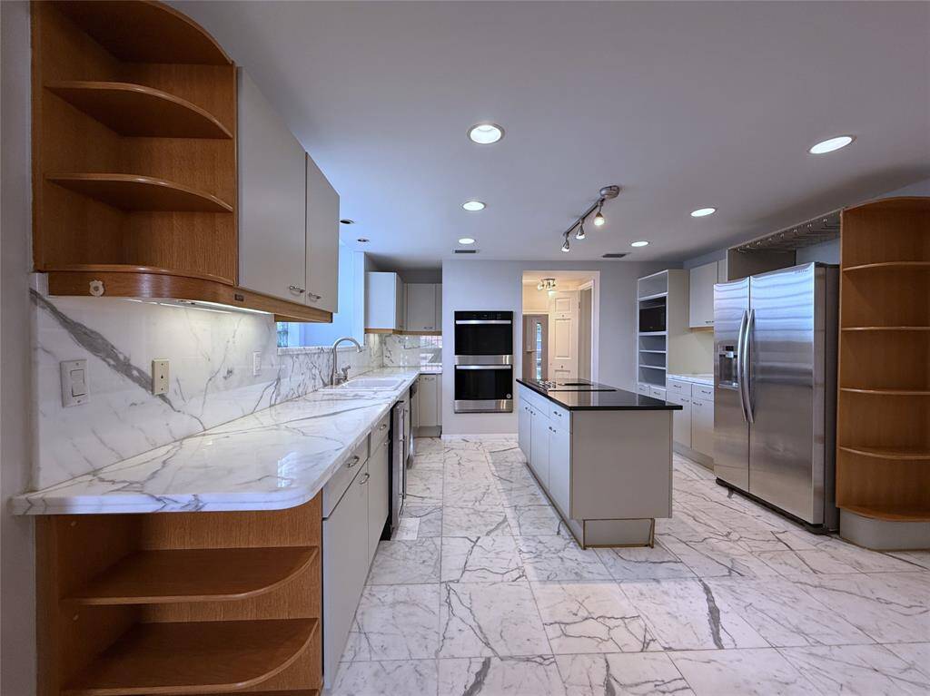 The kitchen features marble counter tops and marble flooring, recessed lighting, track lighting and under-cabinet lighting.