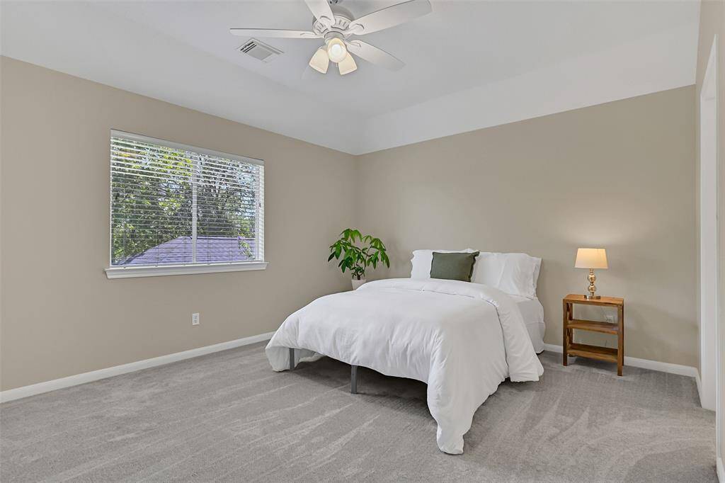 This secondary bedroom offers a walk-in closet, direct access to the Jack & Jill bathroom, fresh paint, brand new carpet, and a newly installed ceiling fan for added comfort.
