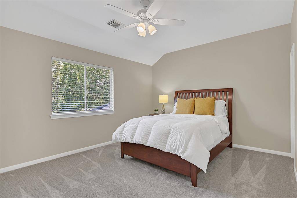 The fourth and final bedroom features brand new carpet, fresh paint, a lighted ceiling fan, dual walk-in closets, and a side-facing window with 2-inch blinds that bring in soft natural light.
