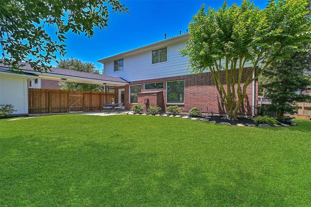 Expansive backyard with mature landscaping, a large patio for entertaining, and a covered breezeway connecting the home to the freshly painted 3-car detached garage. A perfect outdoor space with privacy and plenty of room to play or garden.2/2