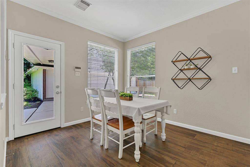 Enjoy a casual meal in this charming breakfast nook with a pair of windows and a full-panel glass door for backyard views and direct patio access. Extra-wide plank wood-look tile floors make for easy clean-up, as well.