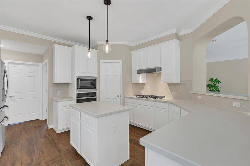 The kitchen offers a walk-in corner pantry, a built-in oven and microwave, gas cooktop with vent hood, and a spacious butler’s pantry that connects directly to the dining room—perfect for entertaining and additional storage.