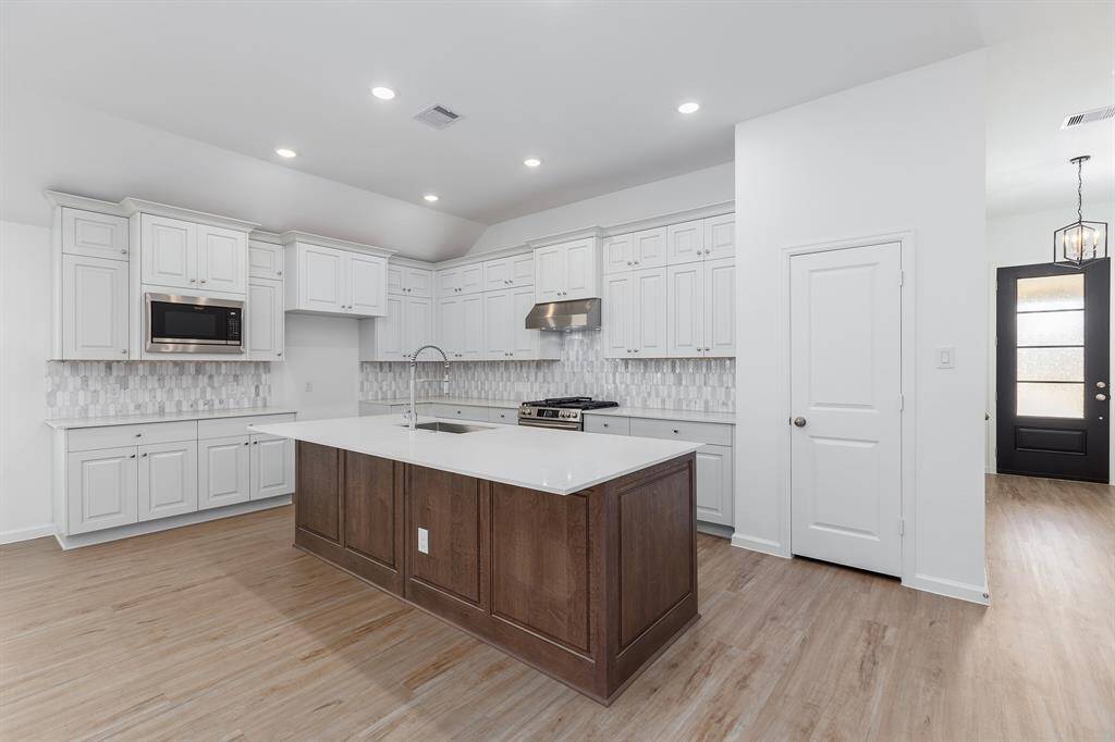 Massive kitchen with stylist tile backsplash and Quartz countertops