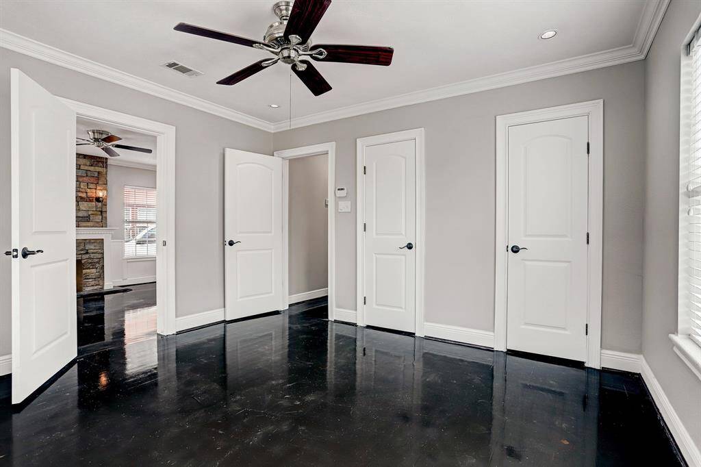 SUNLIT SECONDARY BEDROOM OFFERS CEILING FAN WITH DOOR LEADING TO UTILITY ROOM.