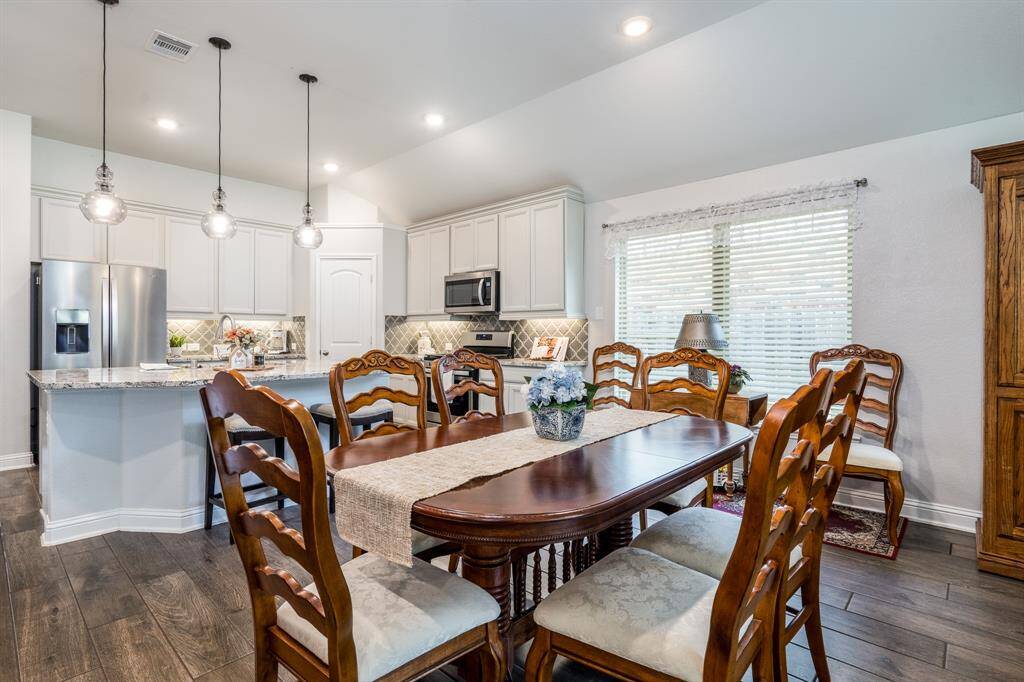 Just off the kitchen, you'll find the dining room, ideal for formal meals or family gatherings, with large windows that fill the space with natural light and offer views of the outdoors